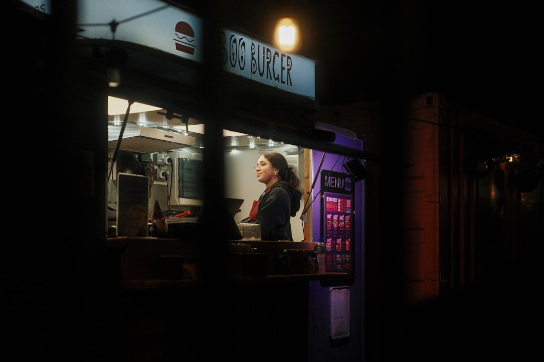 Woman working at a food truck at night.