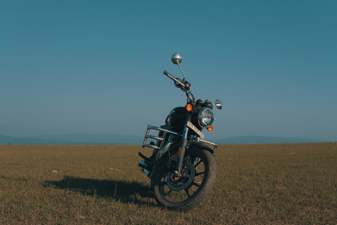 A black motorcycle parked on a grassy field.