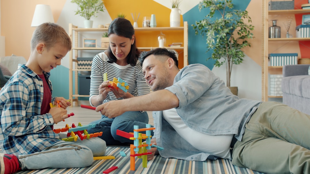 Family building with colorful toy blocks together on floor