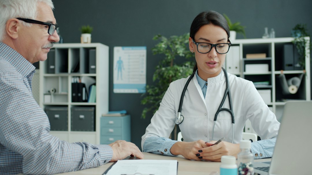Doctor consulting with an elderly patient in an office