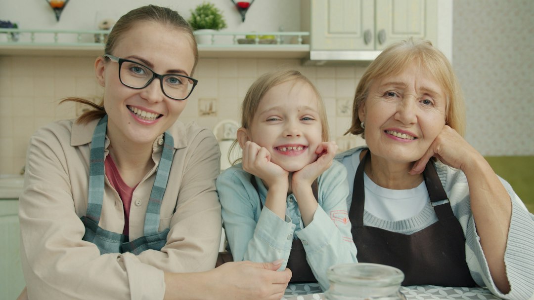 Three smiling women of different ages in a kitchen